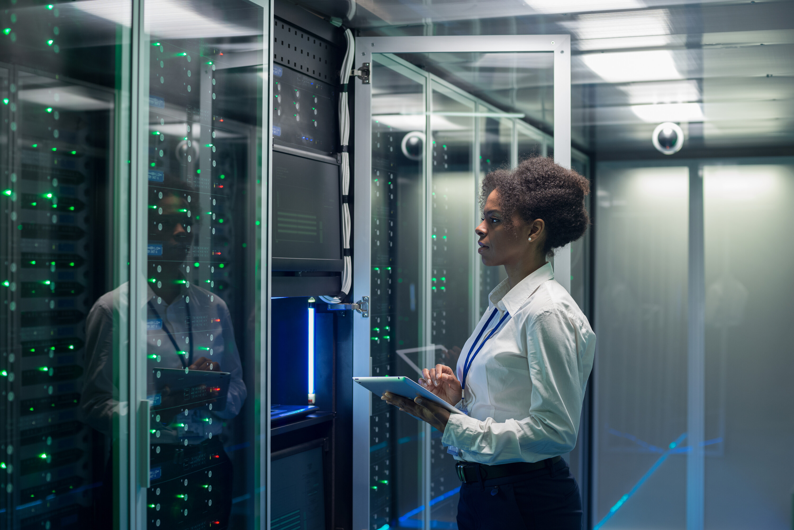 Female technician works on a tablet in a data center